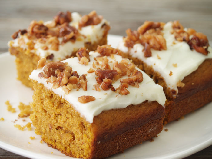 Moist pumpkin bars topped with creamy white frosting and chopped walnuts.