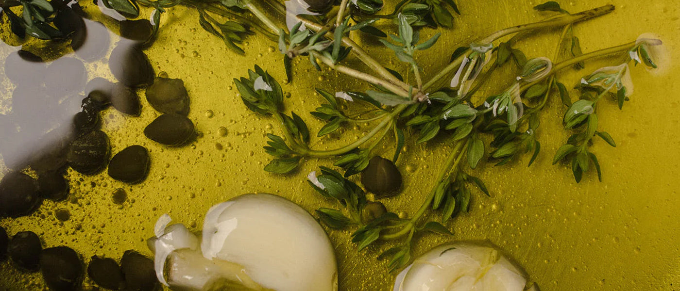 Olive oil infused with garlic cloves, fresh thyme sprigs, and whole black peppercorns.