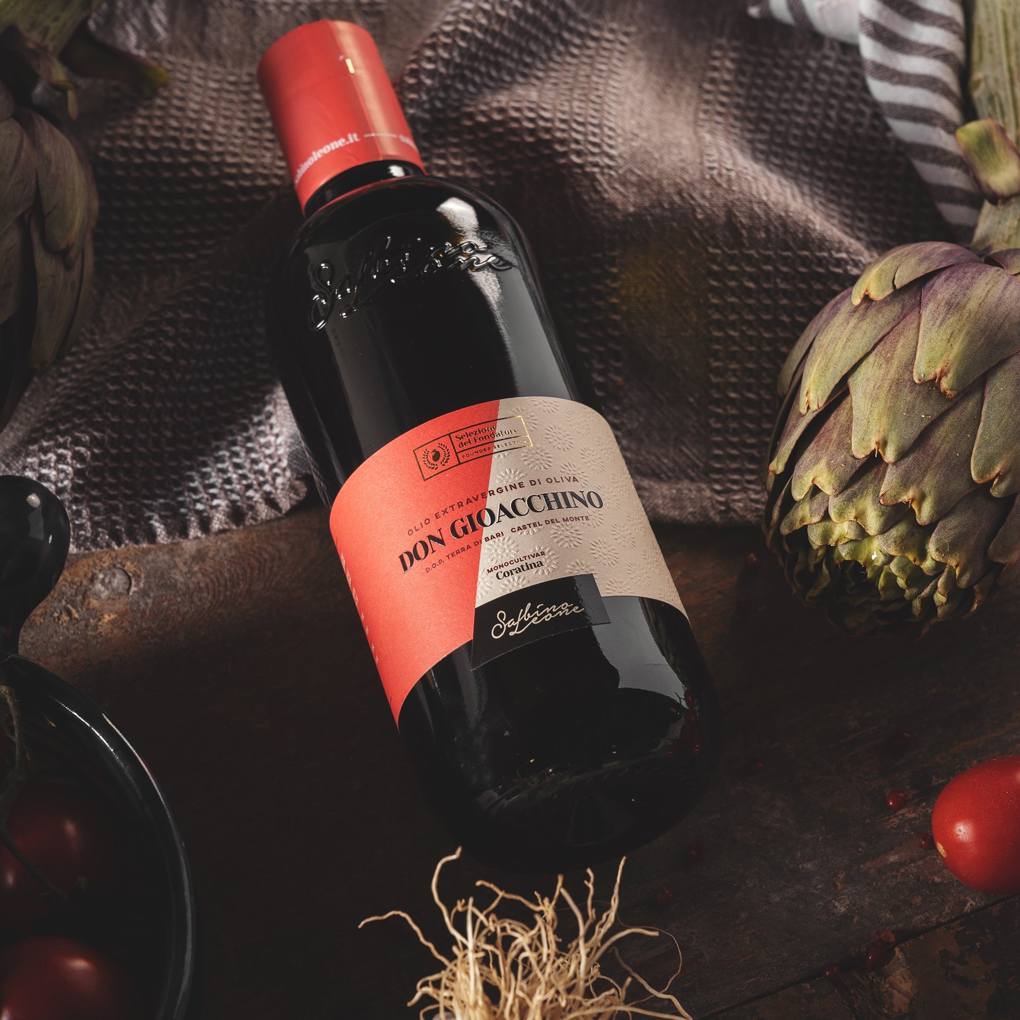 Sabino Leone Don Gioacchino 500 ml bottle lying beside an artichoke, and tomatoes.